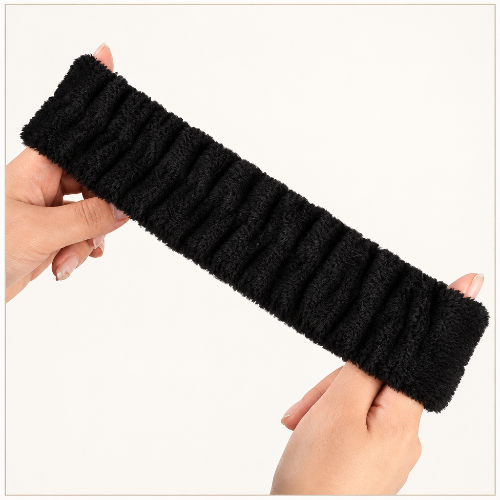 Bandeau cheveux pour maquillage noir en tissu plisse etire entre deux mains sur fond clair