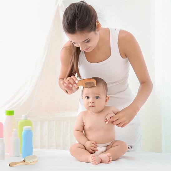 Brosse cheveux pour bébé posee sur la table pendant une coiffure au peigne en bois