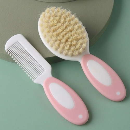 Brosse cheveux pour bébé et peigne assorti avec manches roses et blancs sur fond vert