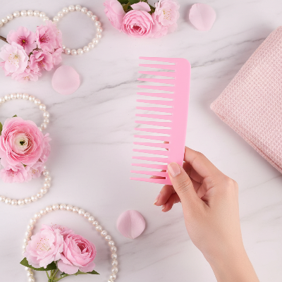peigne à dents larges rose antistatique tenu en main