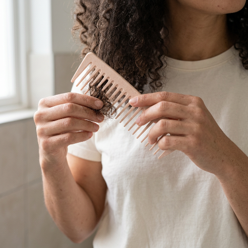 Peigne dents larges rose sur une meche bouclee