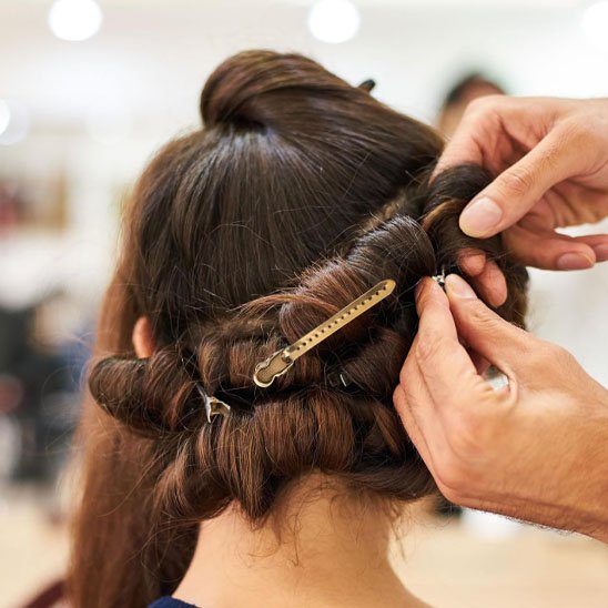 Pince-à-cheveux-doree-utilisee-pour-maintenir-meches-lors-de-coiffage-en-salon