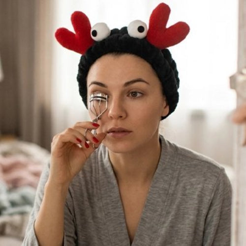 Bandeau maquillage noir ornements rouges yeux mobiles femme utilise recourbe cils pour maquillage des yeux