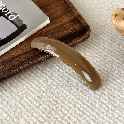 barrette-cheveux-marron-presenter-sur-un-tapis-blanc