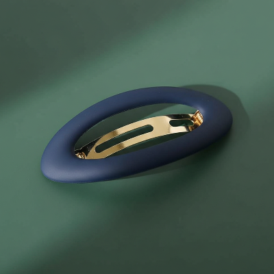barrette pour cheveux clip bleu oval sur surface verte