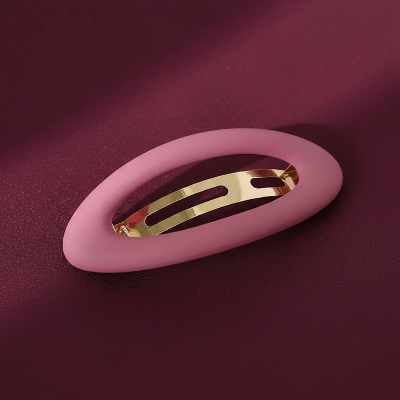 barrette pour cheveux clip rose oval sur surface foncee