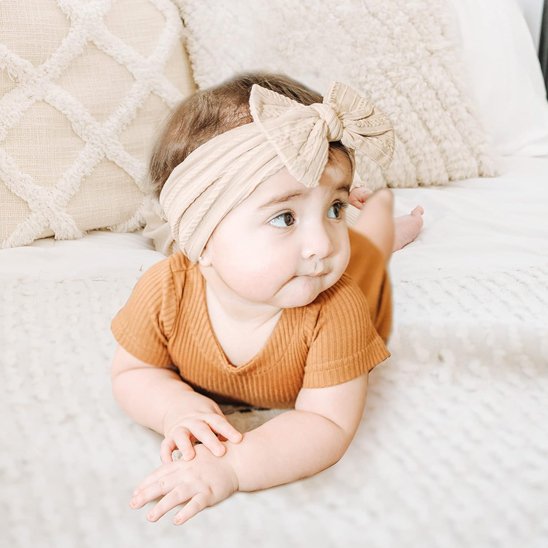 bebe-allonge-douceur-neutre-bandeau-cheveux-bebe-noeud-beige-tenue-cocooning-lit
