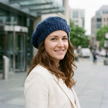 Béret bleu marine en chenille porte par une femme en blazer creme devant un batiment de bureaux