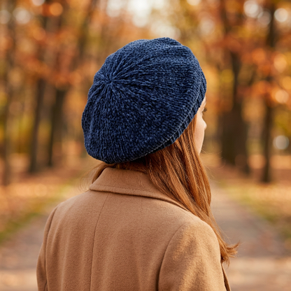 Béret bleu marine en chenille porte par une femme vue de trois quarts arriere montrant les mailles au sommet et le tombe du beret