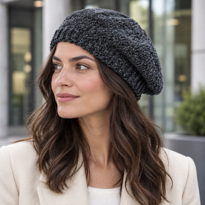 Béret gris fonce en chenille porte par une femme brune en blazer creme devant un batiment de bureaux