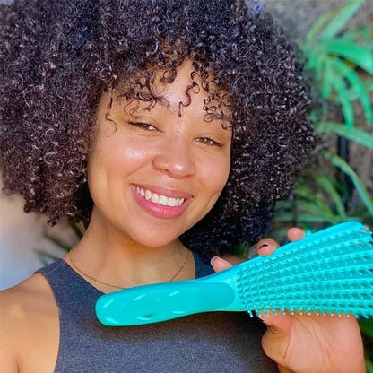 Brosse à cheveux  verte boucle cheveux femme souriante