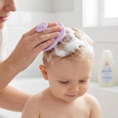 Brosse cheveux bébé violette utilisee pour laver les cheveux couverts de mousse