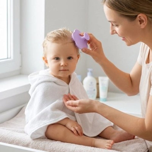 Brosse cheveux bébé violette utilisee sur un enfant enveloppe dans une serviette blanche