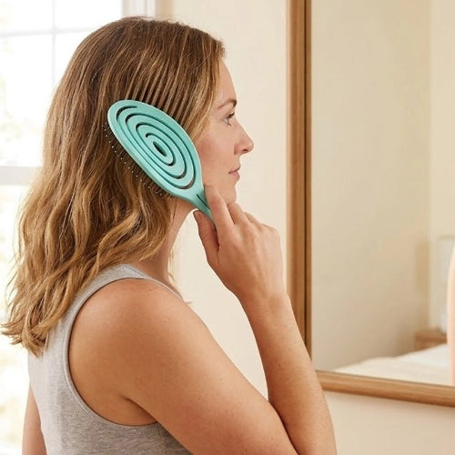 Brosse cheveux boucles turquoise tenue contre le cote de la tete d une femme de profil