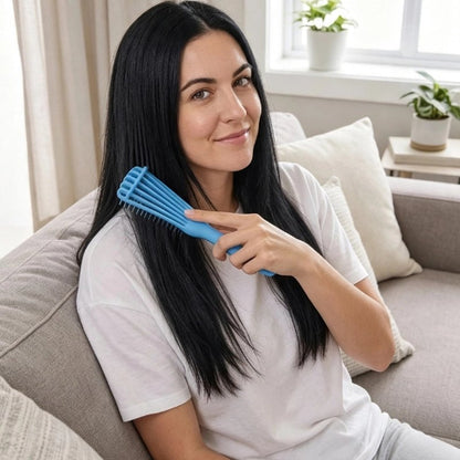 Brosse pour cheveux bouclés bleue utilisee sur les cheveux longs et lisses par une femme sur un canape