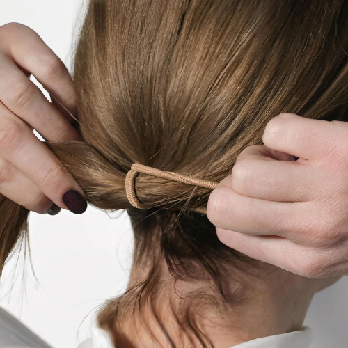 Élastiques pour cheveux beiges pour attacher des cheveux chatains en queue de cheval a la nuque