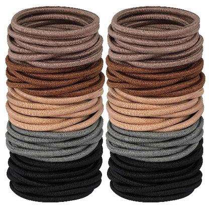 Élastiques pour cheveux taupe marron beige gris et noirs disposes en deux piles sur fond blanc