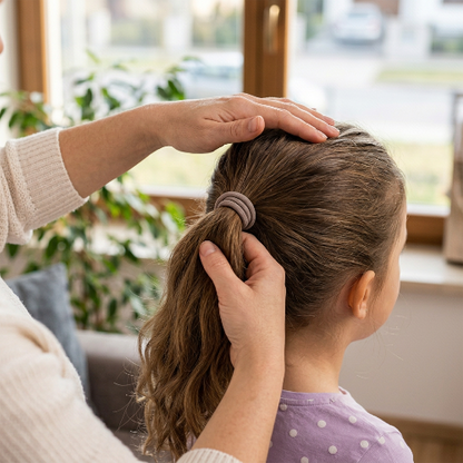 Élastiques pour cheveux taupe sur la queue de cheval d une petite fille pres d une fenetre