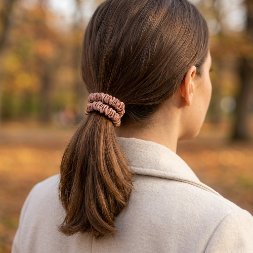 Grand élastique cheveux rose cuivre sur queue de cheval au parc