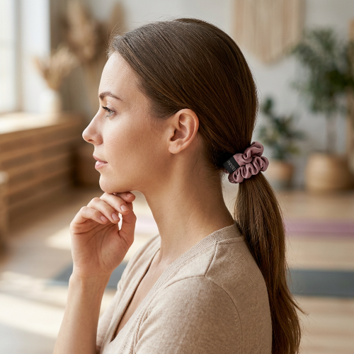Grand élastique cheveux rose sur queue basse de profil