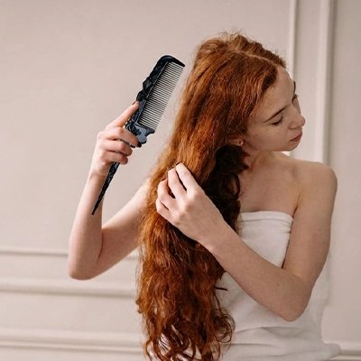 Peigne à cheveux noir pliable femme sortant de la salle de bain cheveux longs roux