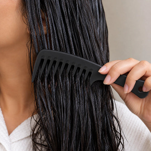  Peigne femme noir a dents larges sur cheveux longs mouilles en gros plan
