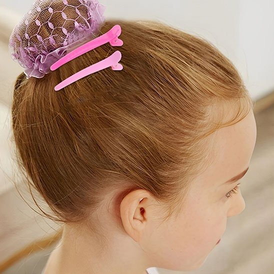 Pinces à cheveux crocodile roses placees pres du chignon
