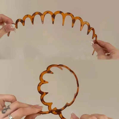 Serre tête chic brun ambre a dents arrondies tenu entre les mains sous deux angles