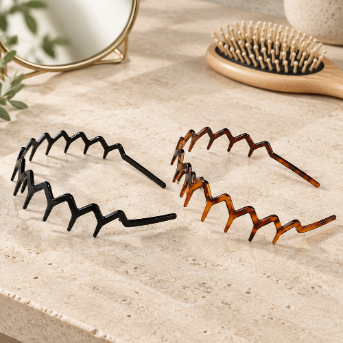 Serre tête chic en zigzag noir et brun ambre presentes sur une surface beige