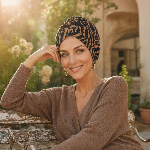 Turban femme a motifs noirs et camel porte dans un jardin ensoleille