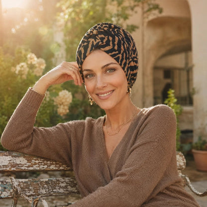 Turban femme a motifs noirs et camel porte dans un jardin ensoleille