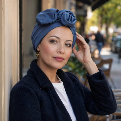 Turban femme bleu avec noeud sur le devant porte avec un manteau noir
