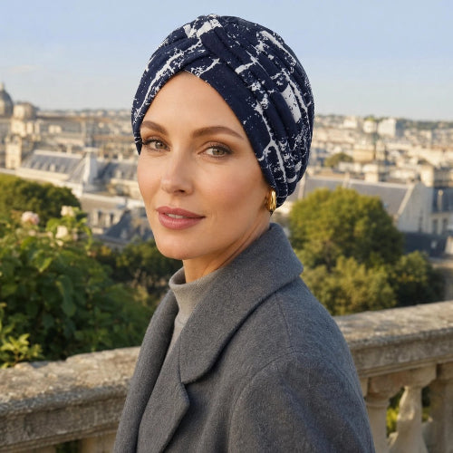 Turban femme bleu marine et blanc avec plis croises porte sur une terrasse