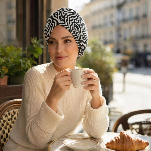 Turban femme zebre noir et blanc porte en terrasse avec une tasse entre les mains