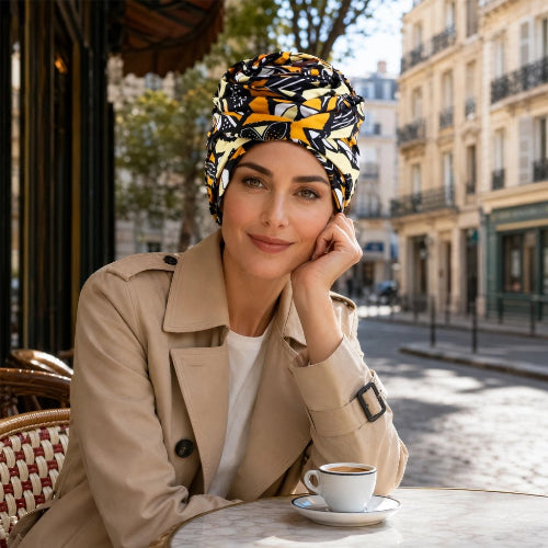 Turban pour femme a motifs jaunes noirs et blancs porte en terrasse de cafe